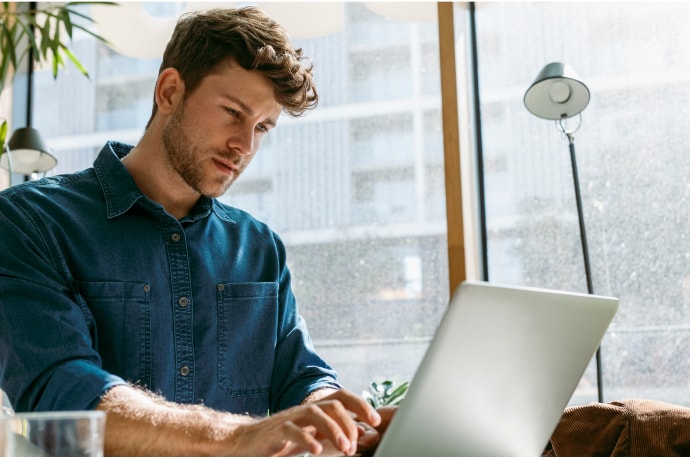 Homem a usar um computador portátil.